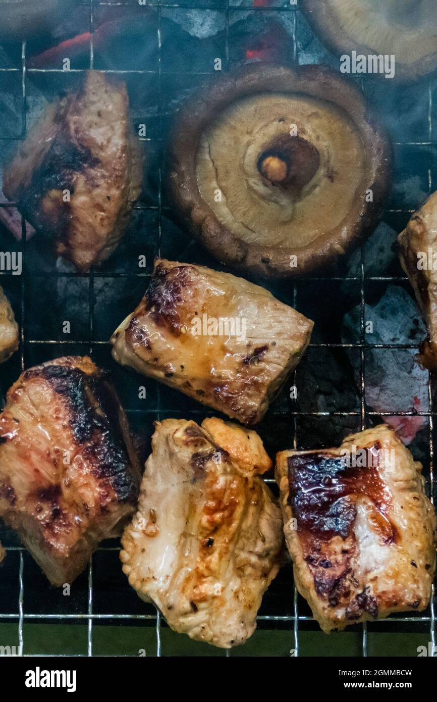 Champignons et grillades de viande sur un barbecue, vue du dessus Banque D'Images
