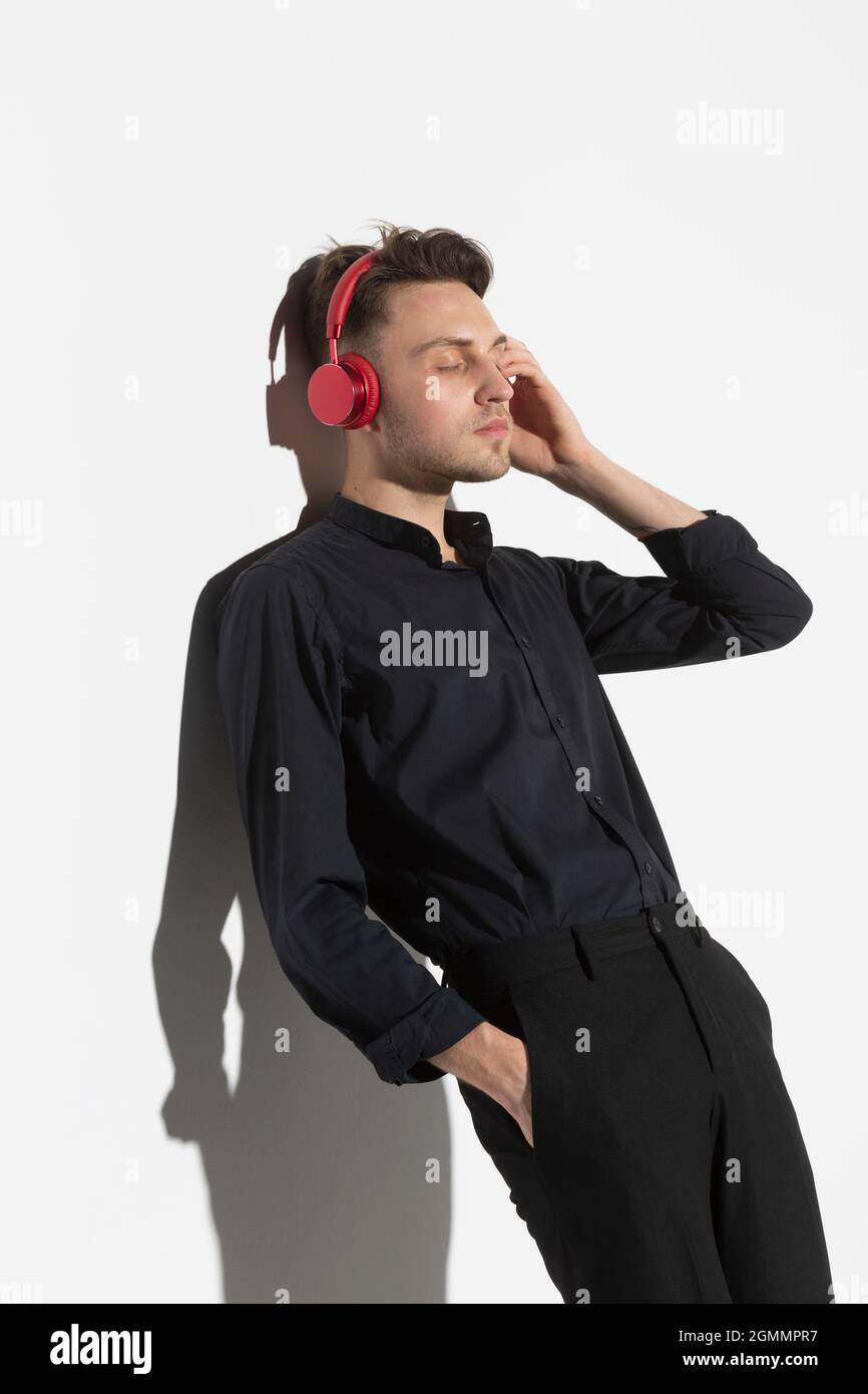 Jeune homme serein avec un casque qui écoute de la musique Banque D'Images