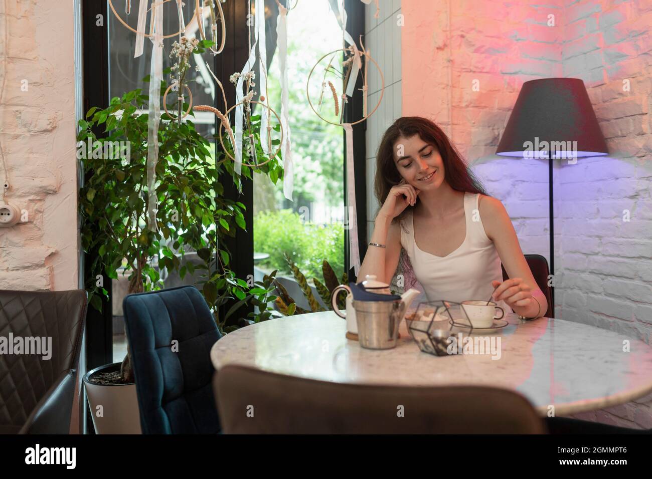 Jeune femme prenant le thé à table de café Banque D'Images