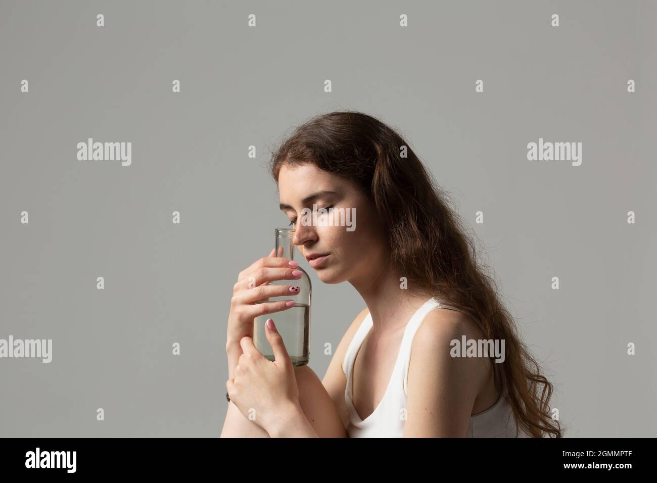 Sereine jeune femme tenant une bouteille d'eau Banque D'Images