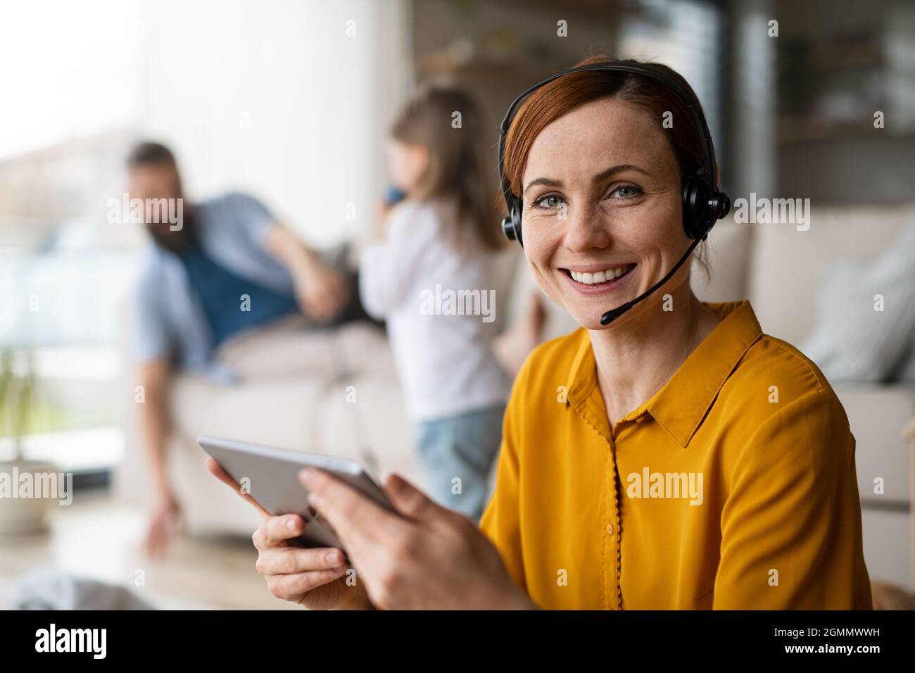 Femme d'affaires avec tablette travaillant à l'intérieur à la maison, la vie quotidienne et le bureau à domicile avec concept enfant. Banque D'Images