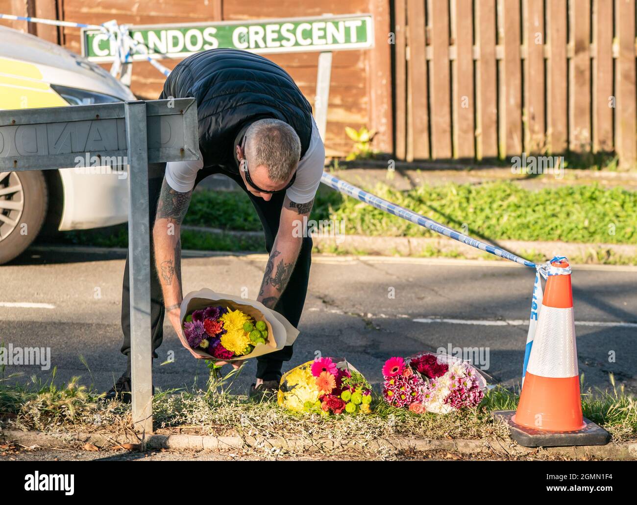 Un homme laisse des fleurs sur la scène de Chandos Crescent à Killamarsh, près de Sheffield, où quatre personnes ont été trouvées mortes dans une maison dimanche. La police de Derbyshire a déclaré qu'un homme est en garde à vue et qu'il ne cherche personne d'autre en relation avec la mort. Date de la photo: Lundi 20 septembre 2021. Banque D'Images