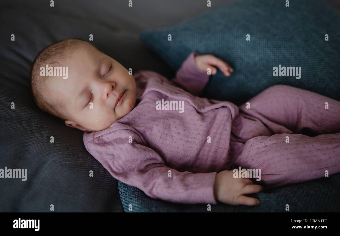 Portrait d'une jeune fille de nouveau-né, dormant sur un canapé à l'intérieur à la maison. Banque D'Images