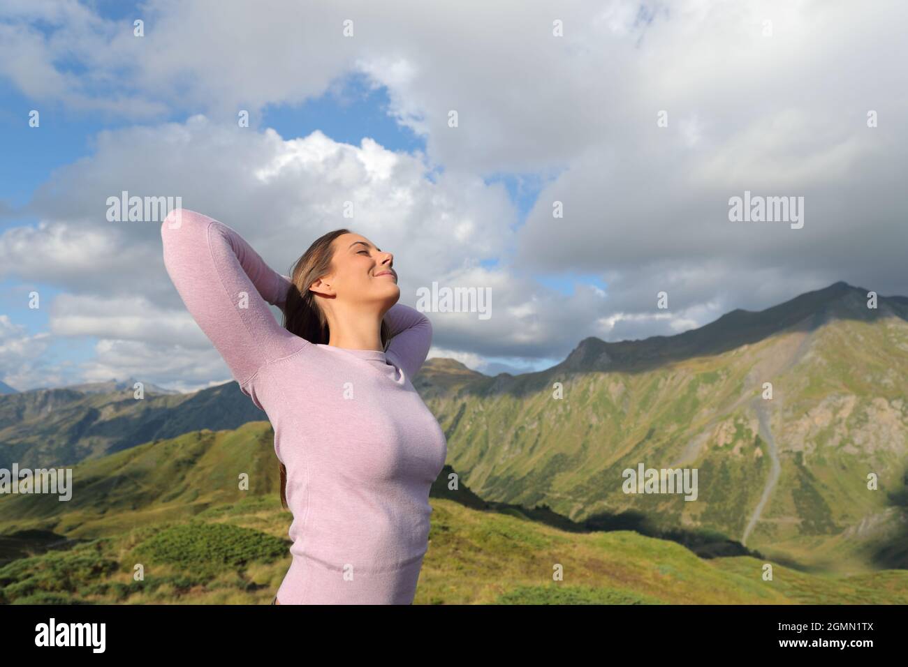 Femme décontractée respirant de l'air frais dans la montagne Banque D'Images
