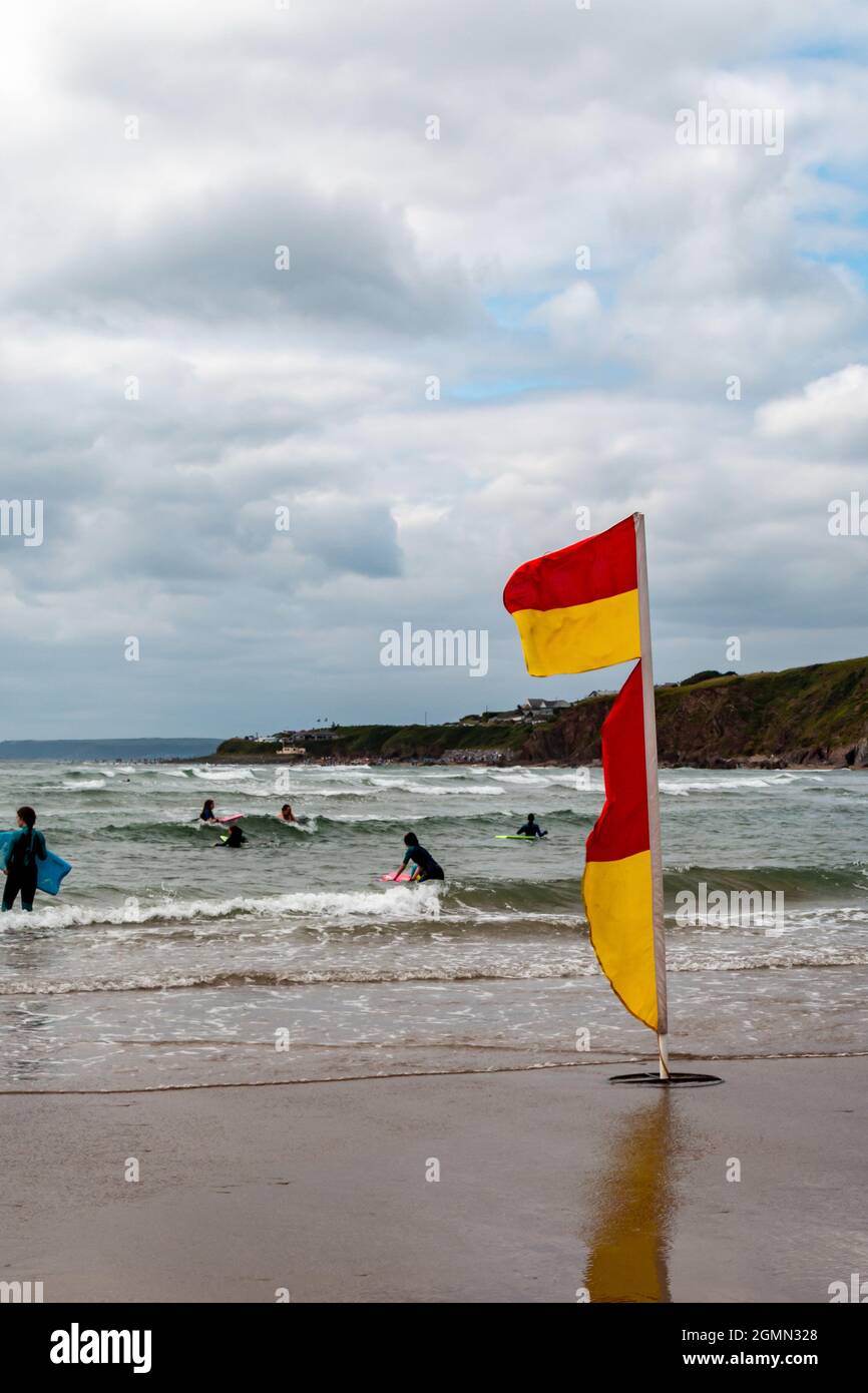 Les drapeaux rouges et jaunes de la RNLI indiquent où il est sécuritaire de nager sur la plage de Bantham, Devon. Banque D'Images