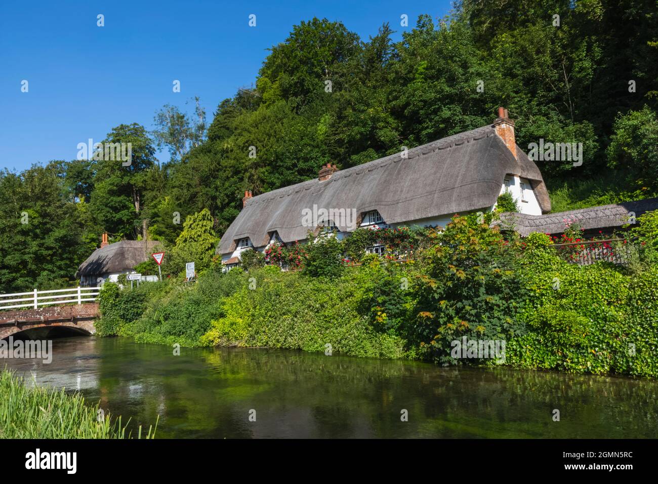 Angleterre, Hampshire, Test Valley, Wherwell, maison de campagne traditionnelle de chaume et River Test Banque D'Images