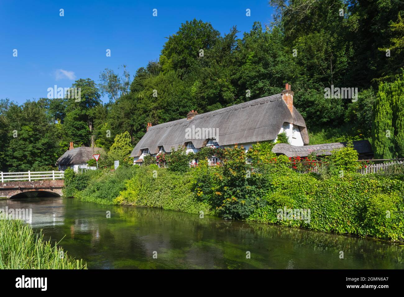 Angleterre, Hampshire, Test Valley, Wherwell, maison de campagne traditionnelle de chaume et River Test Banque D'Images