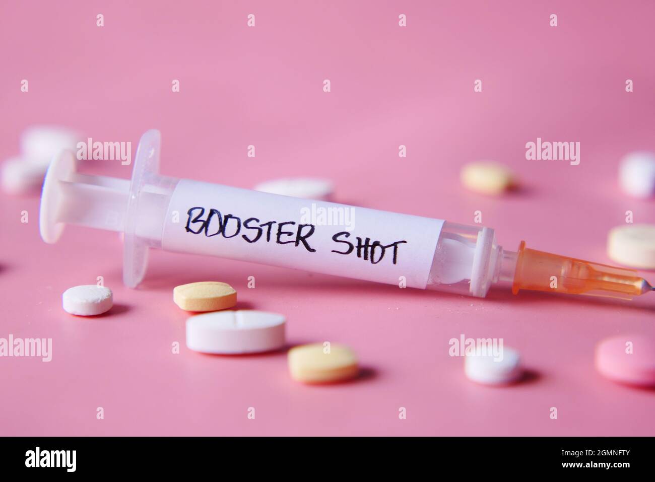 test de dose de rappel sur seringue et pilules sur fond rose, gros plan Banque D'Images