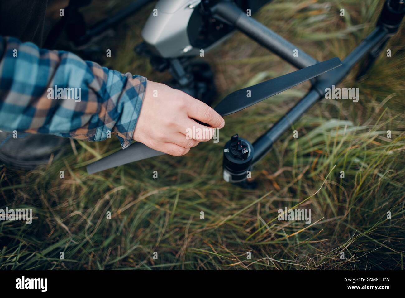 Homme pilote vérifiant les lames d'hélice de drones quadcopter avant le vol aérien et le tournage Banque D'Images
