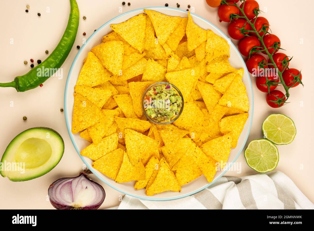 Une assiette de croustilles de maïs nachos avec guacamole et ingrédients, oignon rouge, avacado, poivrons et tomates. Vue de dessus. Banque D'Images