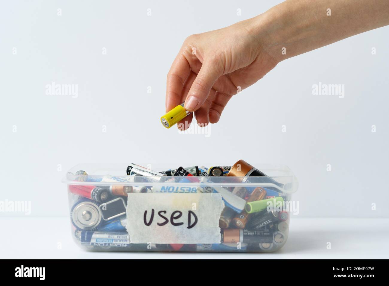 Oslo, Norvège - 15 avril 2021. Bras de mise de fille utilisé batterie déchargée dans un récipient en plastique. Banque D'Images