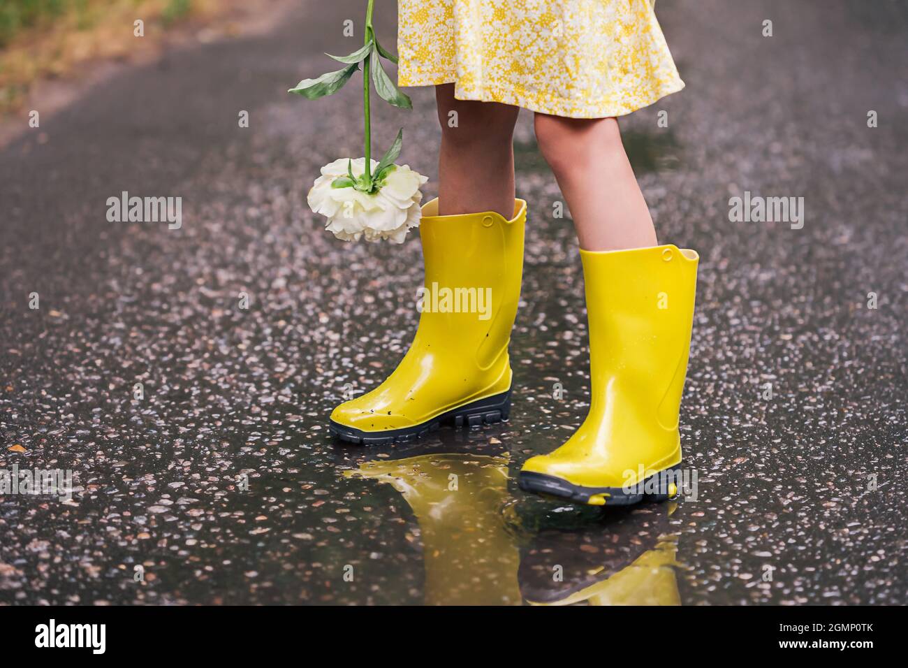 Petite fille portant des bottes de pluie jaunes debout dans Une puddle  Photo Stock - Alamy