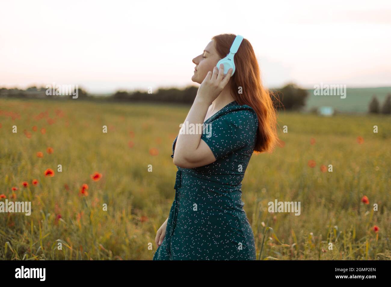 Belle femme joyeuse écouter de la musique sourire porter des écouteurs dans un parc de la ville Banque D'Images