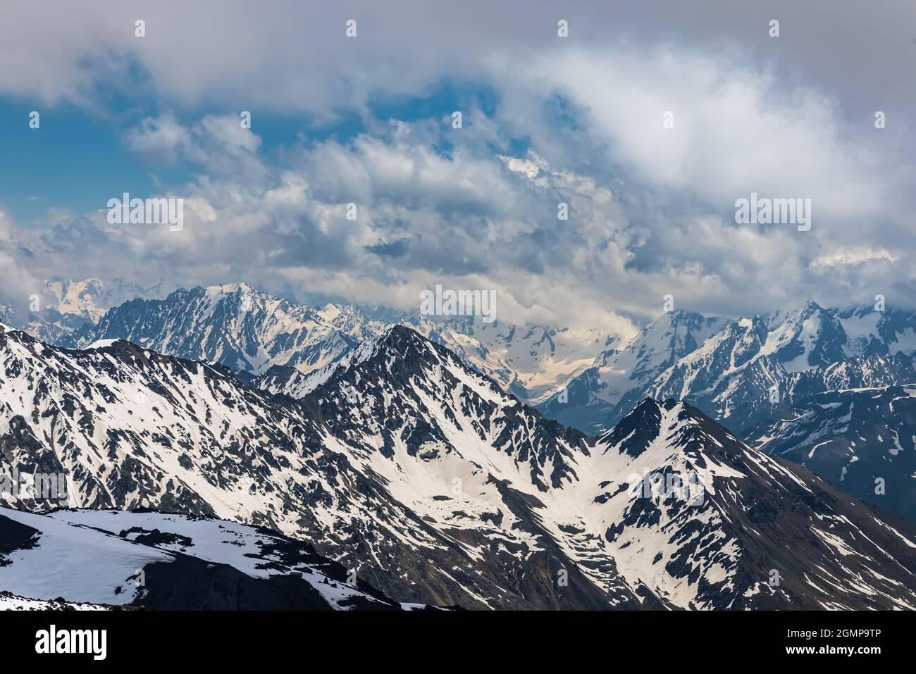 Des nuages de montagne au-dessus de magnifiques sommets enneigés de montagnes et de glaciers. Vue sur les montagnes enneigées. Banque D'Images