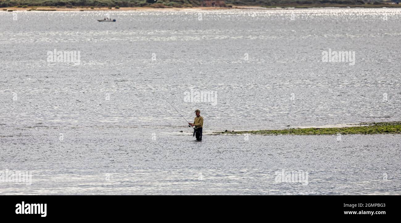 Pêcheur seul pêchant au large de la broche isolée de terre au milieu du port de Poole, Poole, Dorset, Royaume-Uni, le 19 septembre 2021 Banque D'Images