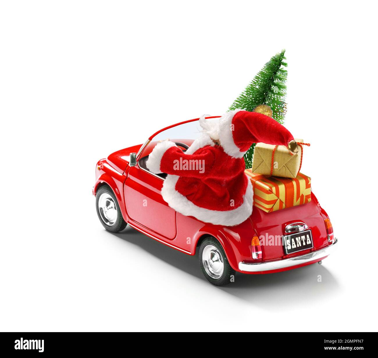 Le Père Noël conduit une voiture rouge avec des boîtes-cadeaux et un arbre de Noël isolé sur blanc, vue de l'extérieur Banque D'Images