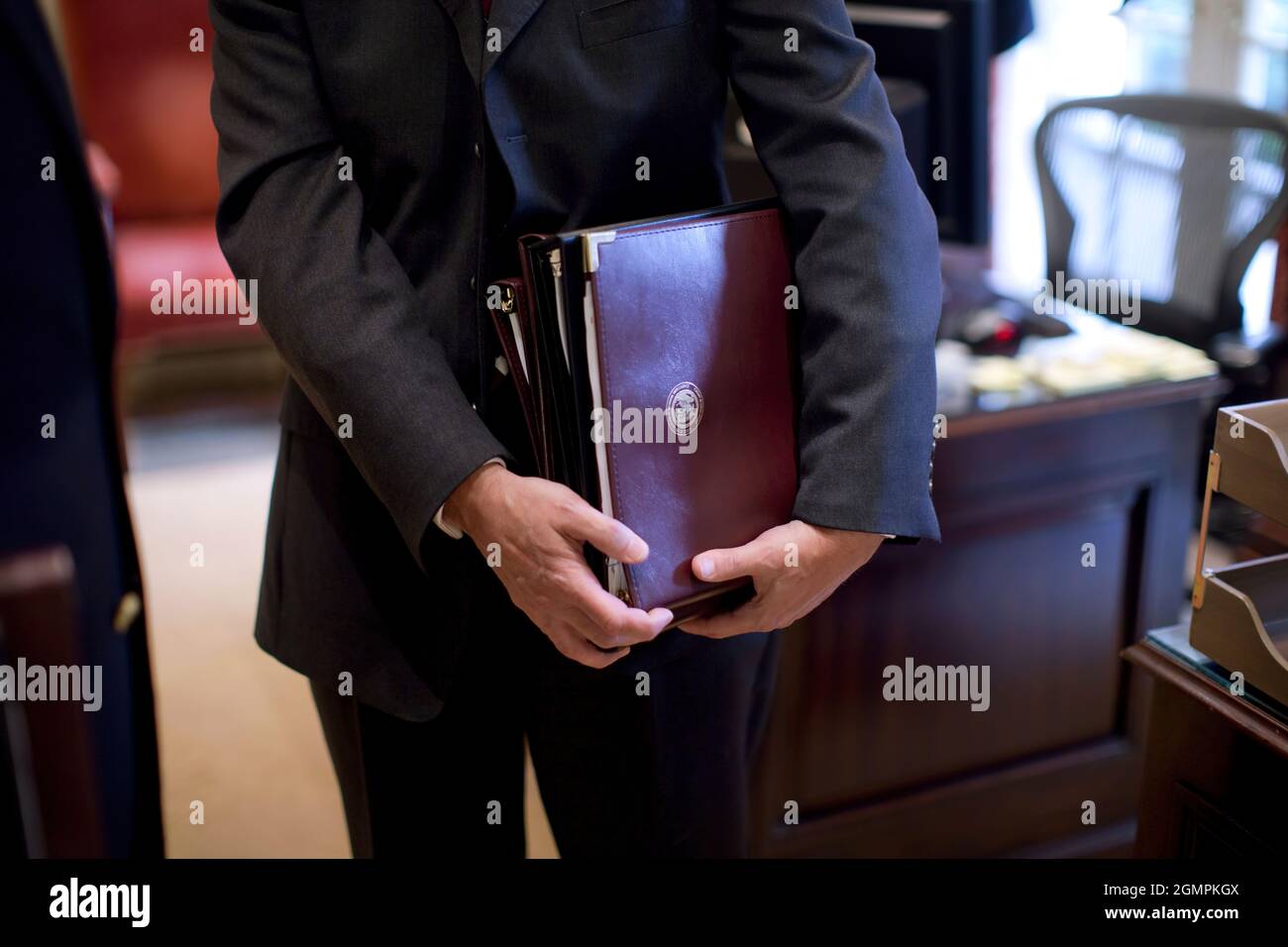 Un briefeur tient un livre d'information avant le briefing quotidien présidentiel (PDB) dans le Bureau ovale extérieur 3/10/09. Photo officielle de la Maison Blanche par Pete Souza Banque D'Images