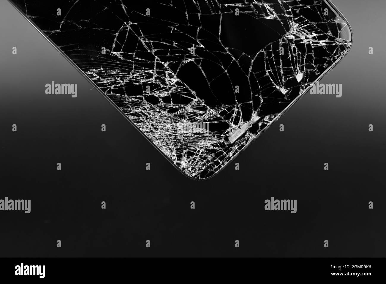 Gros plan d'un smartphone à écran cassé sur fond sombre, smartphone à écran épaté Banque D'Images