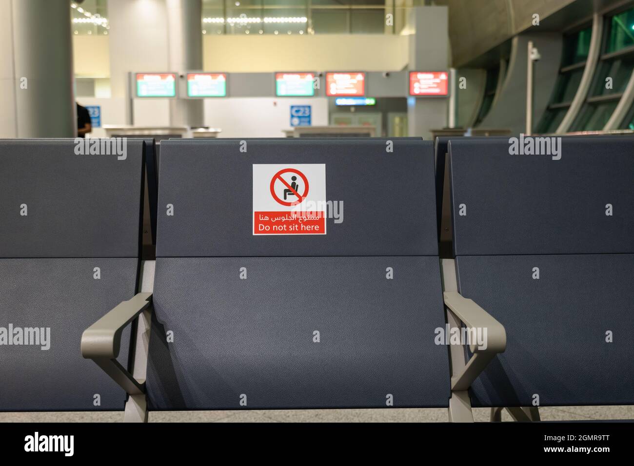 Dubaï, Émirats Arabes Unis - septembre 2021 : chaises avec signe d'avertissement de distanciation sociale à l'aéroport en raison de la pandémie du coronavirus COVID 19. Banque D'Images