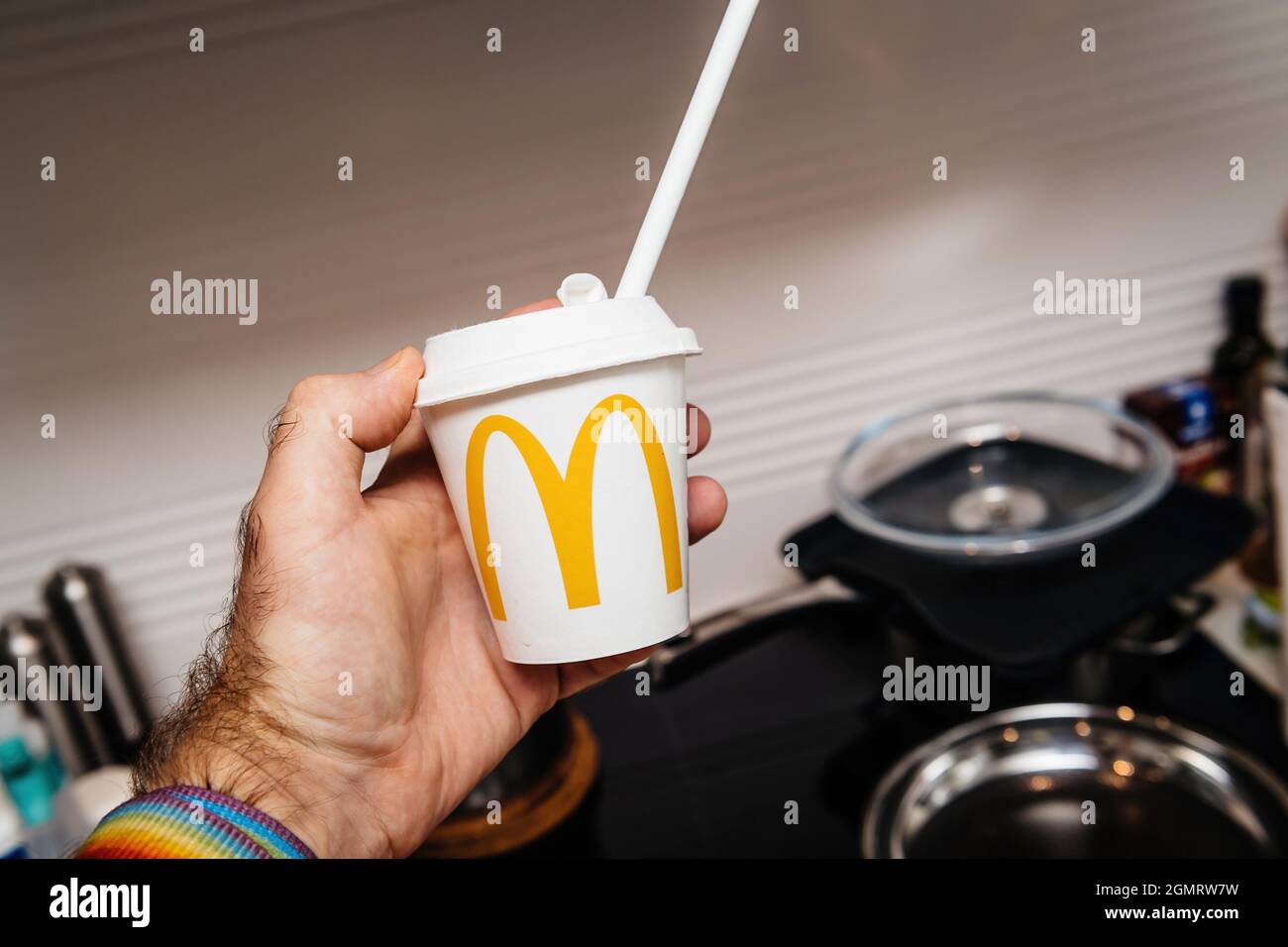 Main mâle POV tenant une tasse en plastique avec le logo McDonald's dessus et de la paille à boire Banque D'Images