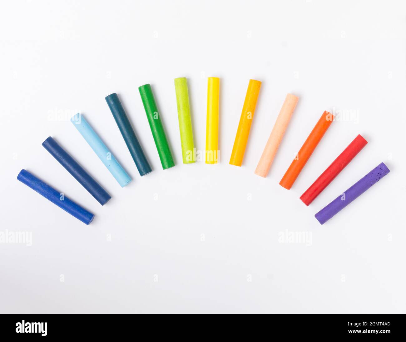 crayons pastel à l'huile disposés dans un style arc-en-ciel sur fond blanc Banque D'Images