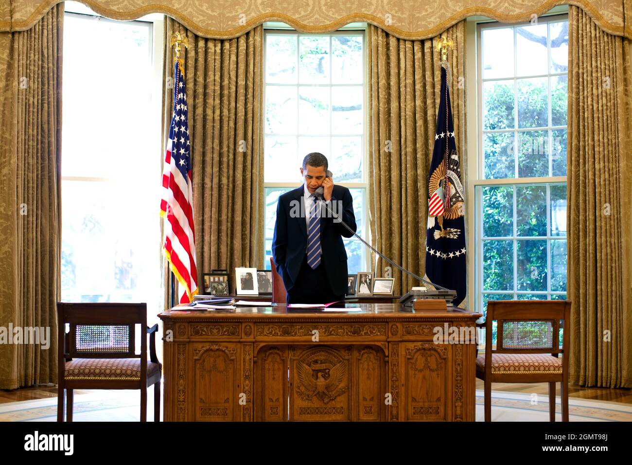 Le président Barack Obama se tient à son bureau tout en parlant au ...
