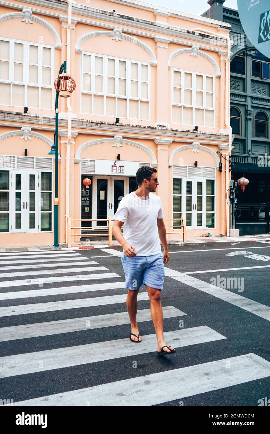 Un homme qui marche de l'autre côté de la rue dans la vieille ville de Phuket, en Thaïlande Banque D'Images