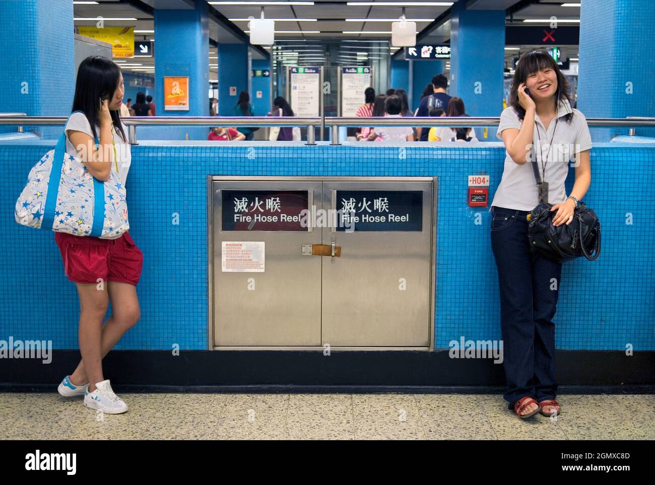Hong Kong, Chine - 28 octobre 2006 ; deux filles et des navetteurs en balle. Comme les filles de toute la planète, ces adolescents de Hong Kong vont maintenant partout Banque D'Images