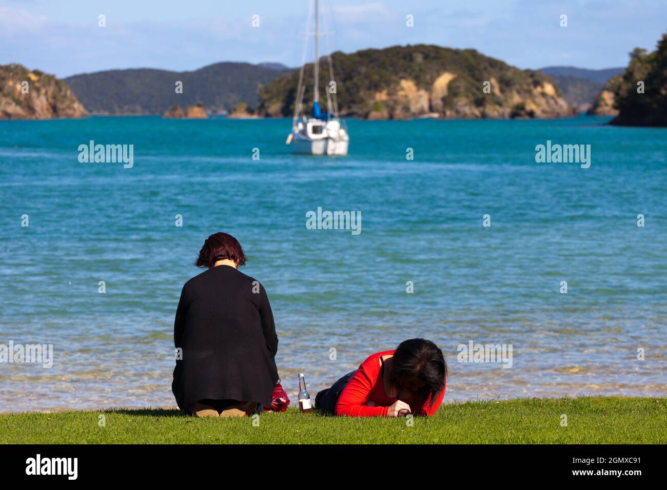 Bay of Islands, Nouvelle-Zélande - 21 mai 2012 deux dames se détendent sur la rive dans la baie des îles, Île du Nord de la Nouvelle-Zélande Banque D'Images