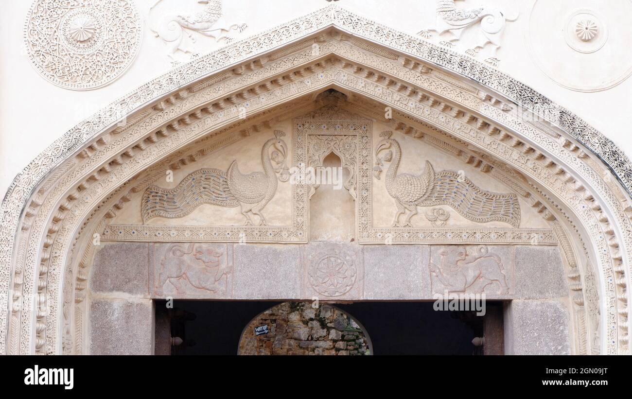 Arche de la porte d'Hissar bordée de rangées de volutes et de paons aux queues ornées. Architecture Qutub shahi Banque D'Images