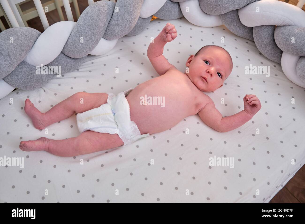 Portrait d'un bébé garçon âgé de 1 mois couché avec ses yeux ouverts dans  un berceau. Enfant caucasien dans la chambre des enfants sur le lit Photo  Stock - Alamy