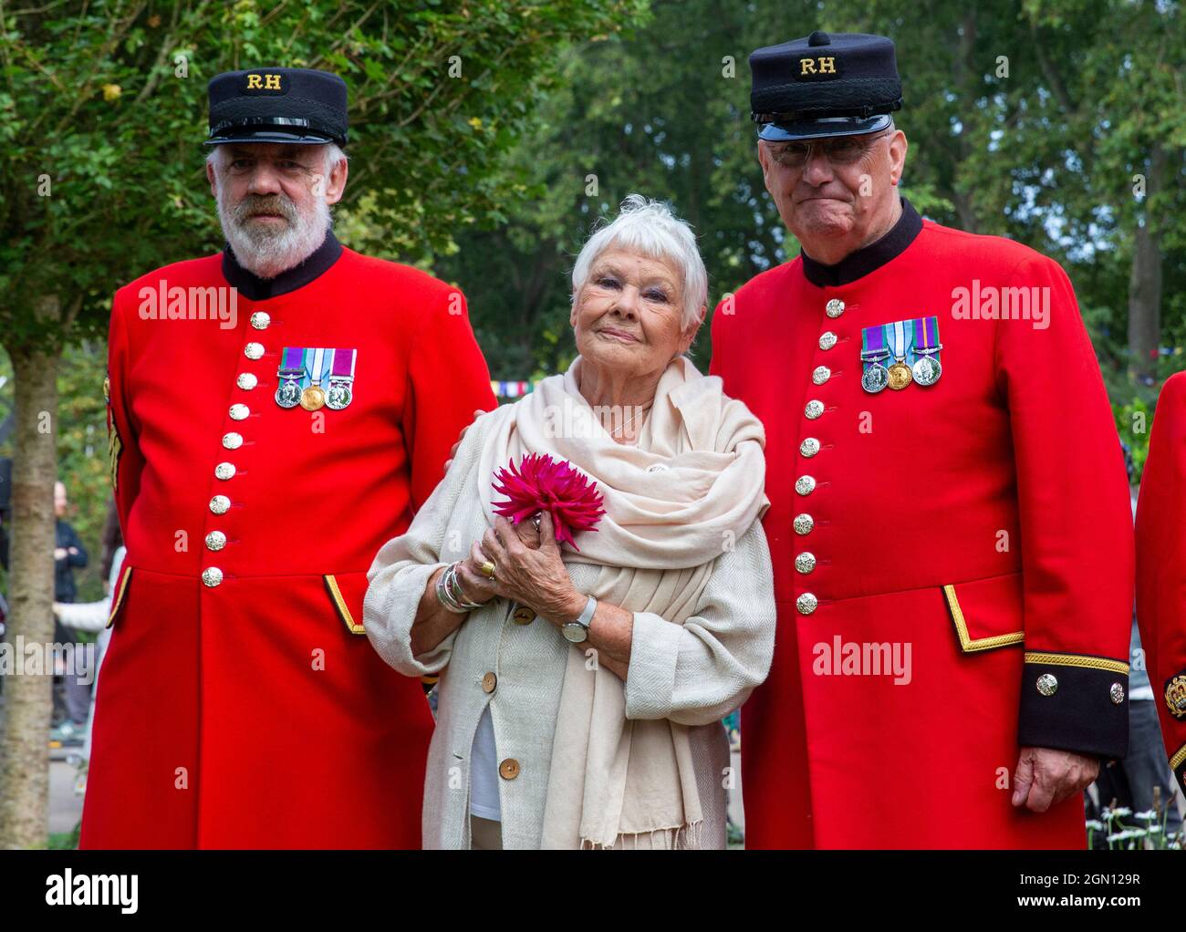 Dame Judi Dench au RHS Chelsea Flower Show posant avec les retraités de Chelsea tout en tenant une rose rouge. Banque D'Images