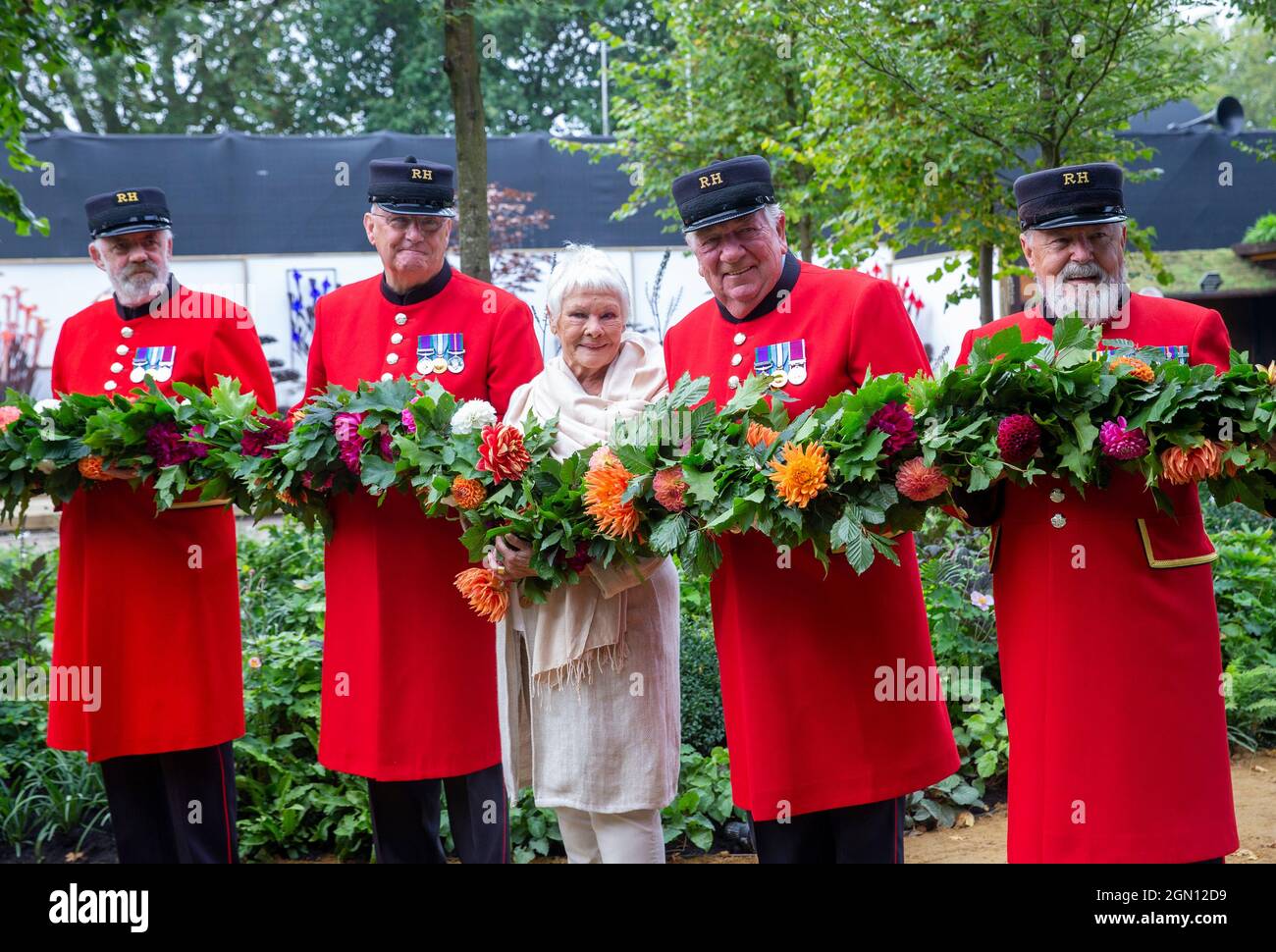 Dame Judi Dench au RHS Chelsea Flower Show posant avec les retraités de Chelsea tout en tenant une rose rouge. Banque D'Images