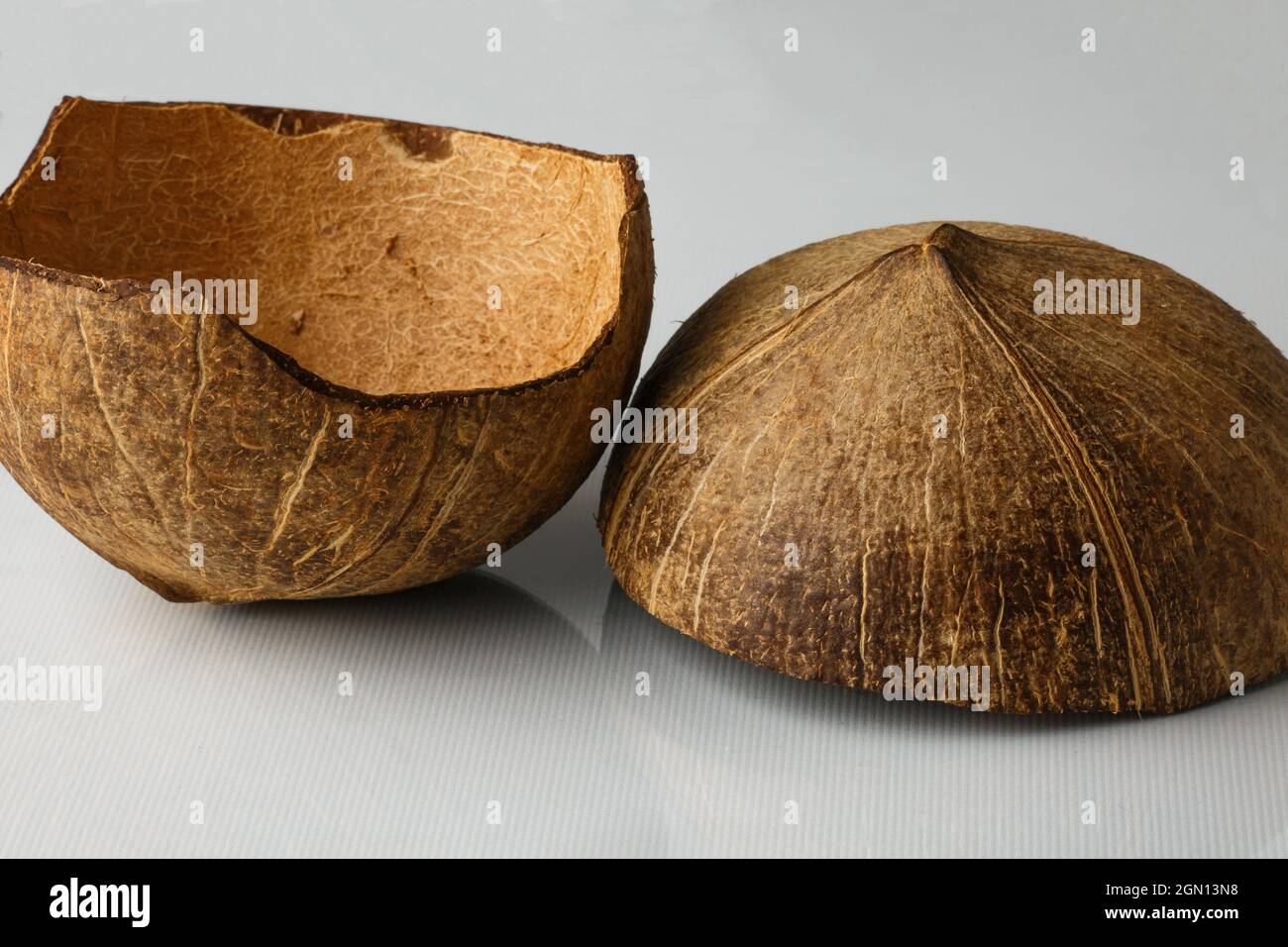 Coque de noix de coco isolée sur fond blanc. Les flocons de noix de coco sont retirés de l'intérieur de la noix de coco. Banque D'Images