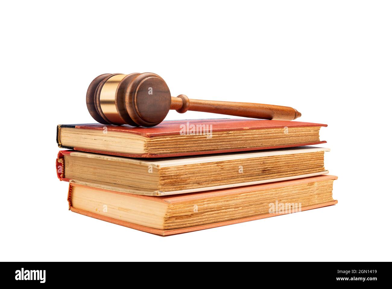 Le gavel d'un juge repose sur trois anciens livres de droit encadrés sur un fond blanc pour faciliter le placement de la copie. Banque D'Images