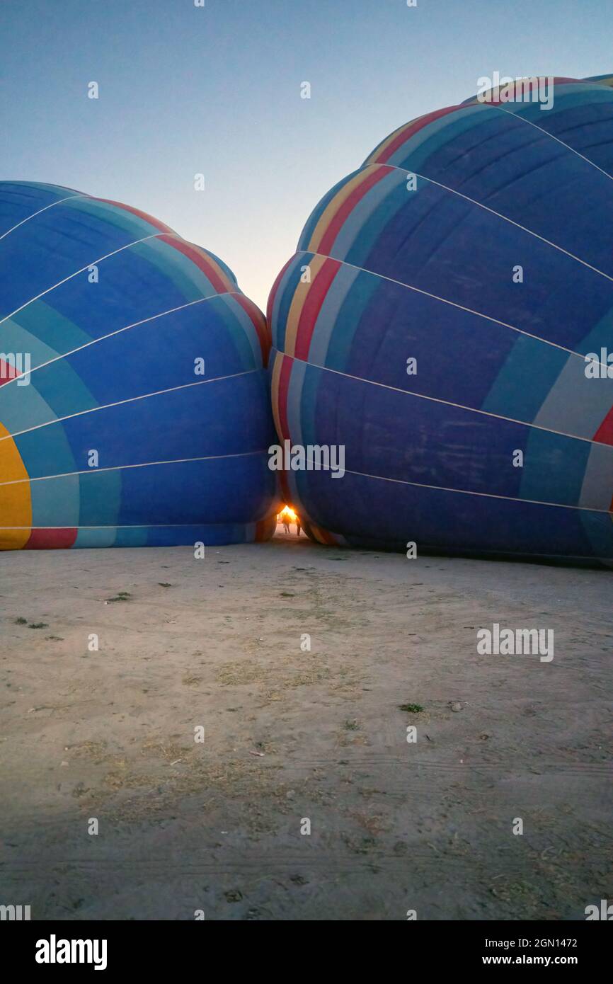 Ballons d'air chaud Coloful face à face étant remplis d'hélium gazeux pendant la nuit, préparation d'un vol dans le parc national de Göreme en Cappadoci Banque D'Images