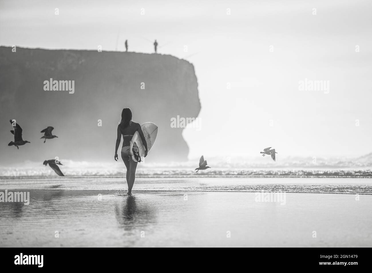 Une femme surfeuse marche sur la plage au Portugal avec sa planche de surf, surf, Portugal Banque D'Images