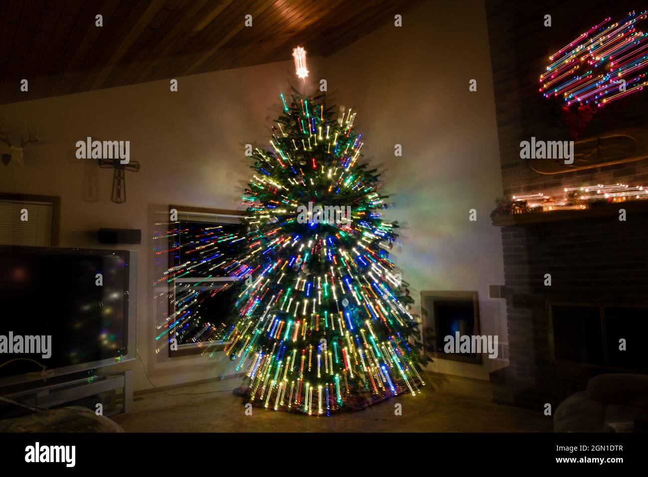 Grande peinture d'arbre de Noël dans la salle de séjour avec couronne et croix. Banque D'Images