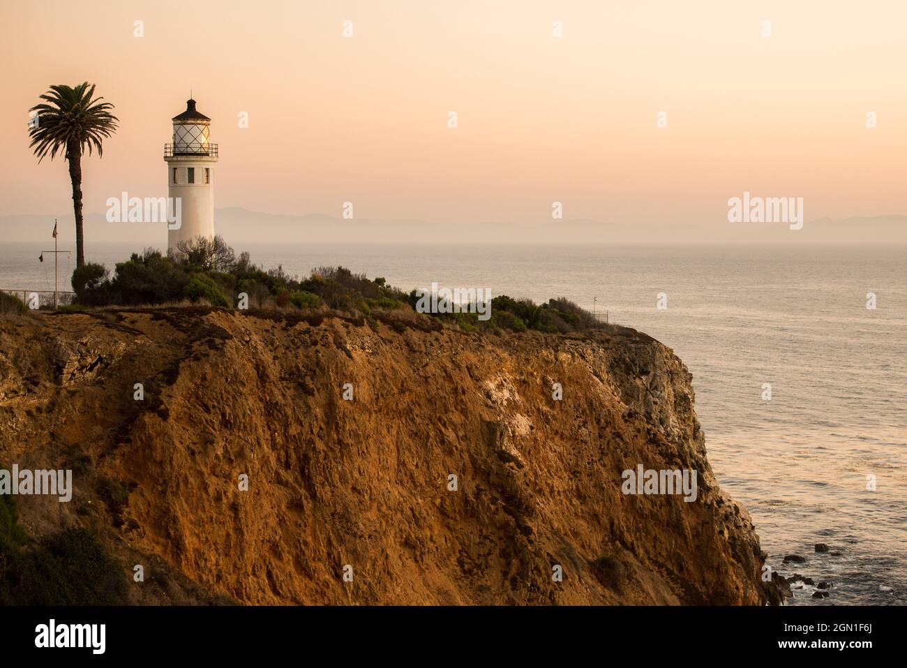 Maison lumineuse et palmier sur une falaise de près Banque D'Images