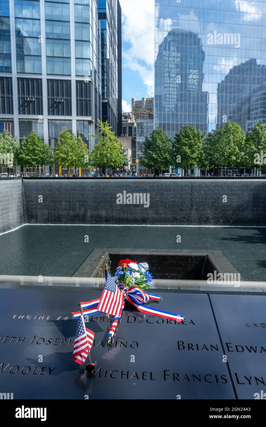 New York, Etats-Unis, 21 septembre 2021 - les drapeaux et les fleurs des Etats-Unis sont vus à côté des noms des victimes de l'attentat terroriste au National septembre 11 Memoria Banque D'Images