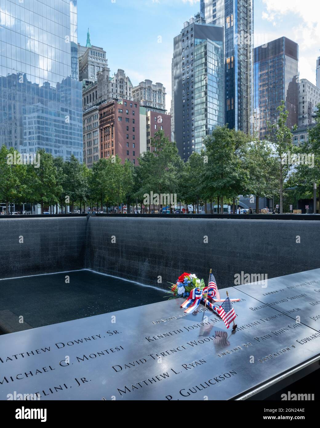 New York, Etats-Unis, 21 septembre 2021 - les drapeaux et les fleurs des Etats-Unis sont vus à côté des noms des victimes de l'attentat terroriste au National septembre 11 Memoria Banque D'Images