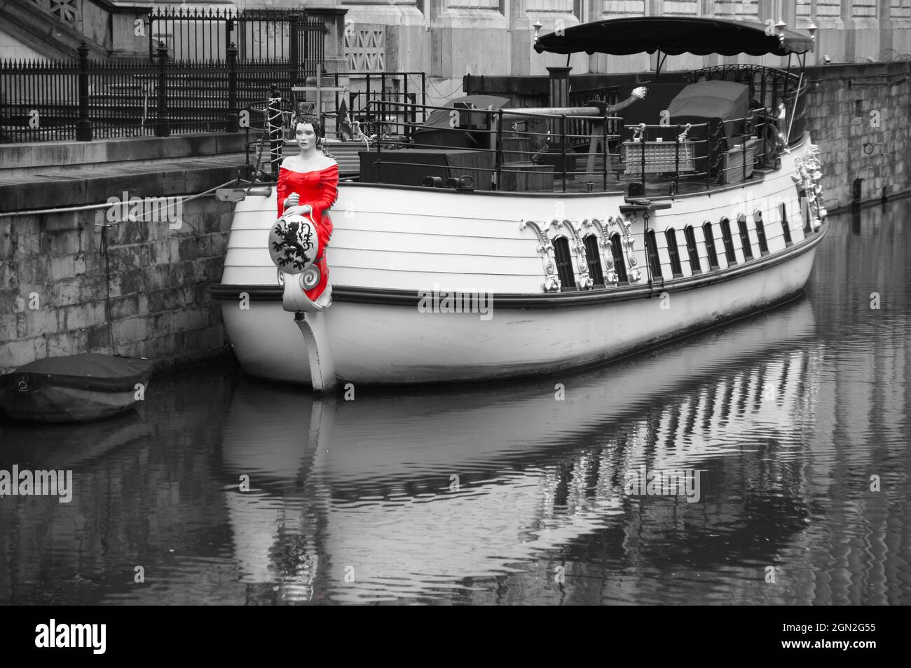 Figurine féminine en robe rouge vif sur un arc de bateau traditionnel amarré à Gand, en Belgique Banque D'Images