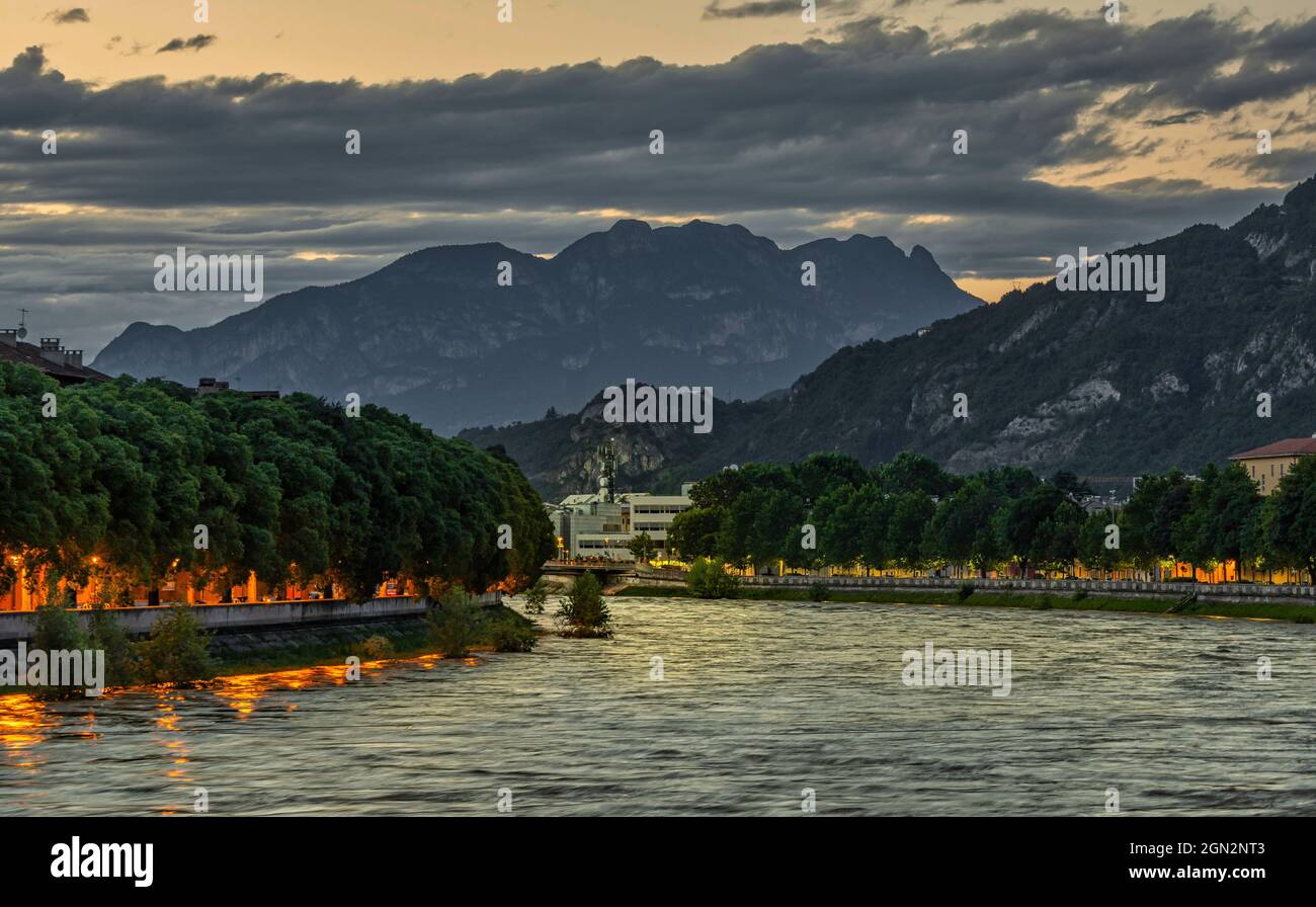 La rivière Adige au crépuscule. En arrière-plan, les sommets des Formigani. Trento, province autonome de Trento, Trentin-Haut-Adige, Italie Banque D'Images