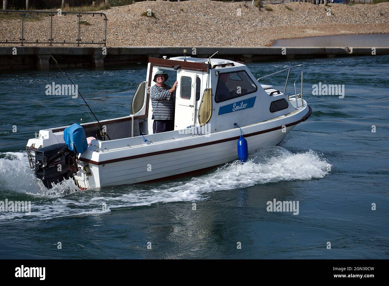 Un petit bateau de pêche appelé Smiler revenant de la mer et se dirigeant le long de la rivière Arun vers Littlehampton. Banque D'Images