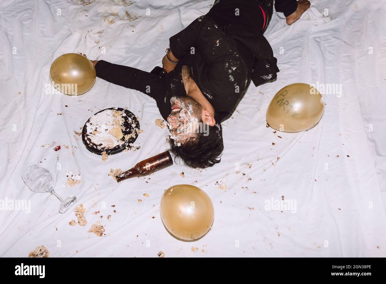 Un Homme Ivre Riant Dans Un Gateau D Anniversaire Ecrase A Proximite De Bouteilles Vides De Biere Et De Ballons Avec Les Yeux Fermes Photo Stock Alamy