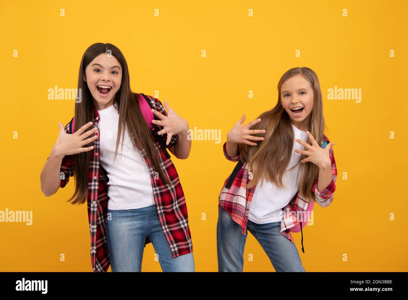 joyeux drôle adolescentes dans décontracté damier chemise porter sac à dos, l'amusement d'école Banque D'Images