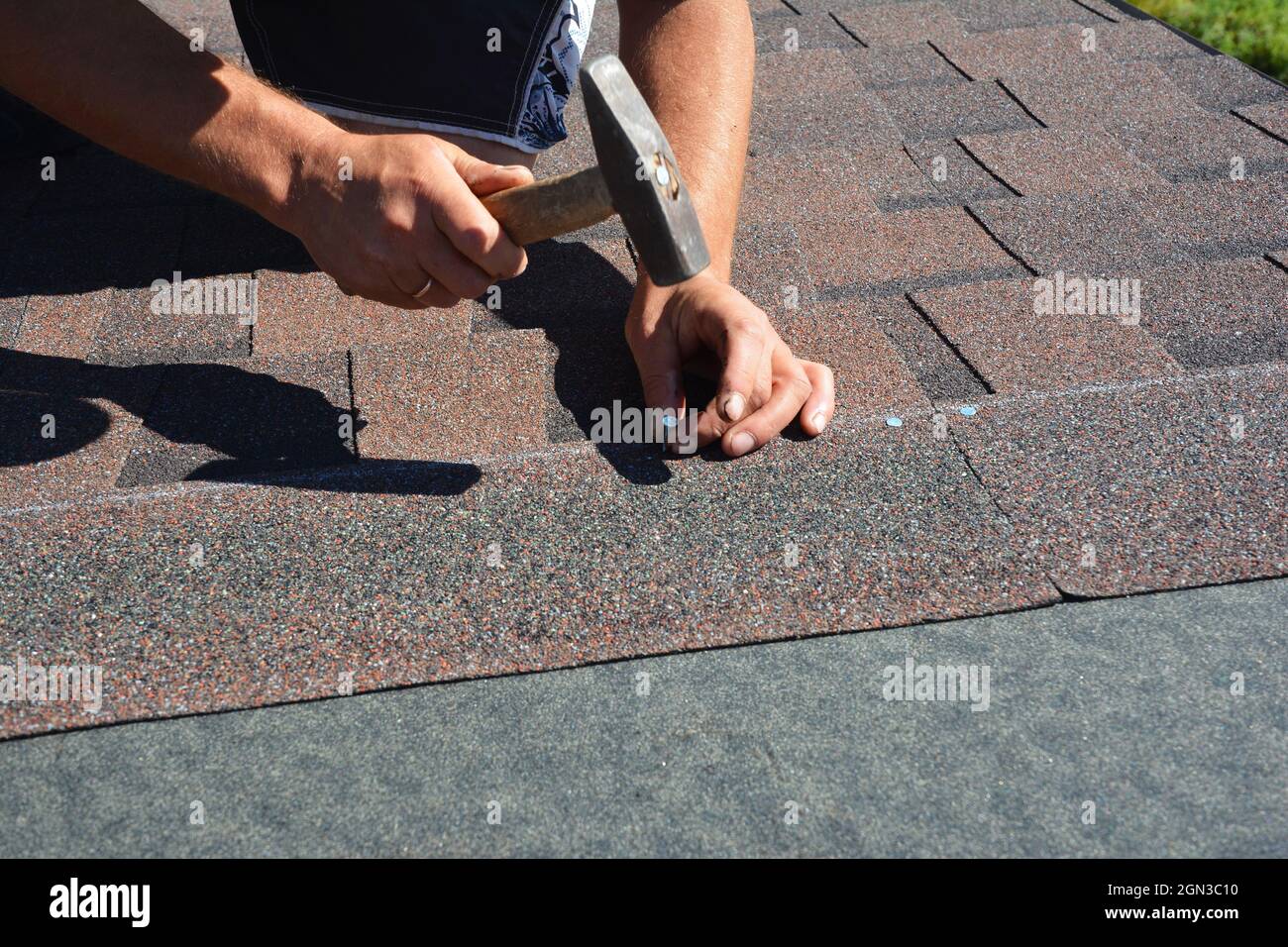 Construction de la toiture. Couvreur installation de bardeaux d'asphalte  sur le coin de toit de construction de maison avec marteau et clous Photo  Stock - Alamy