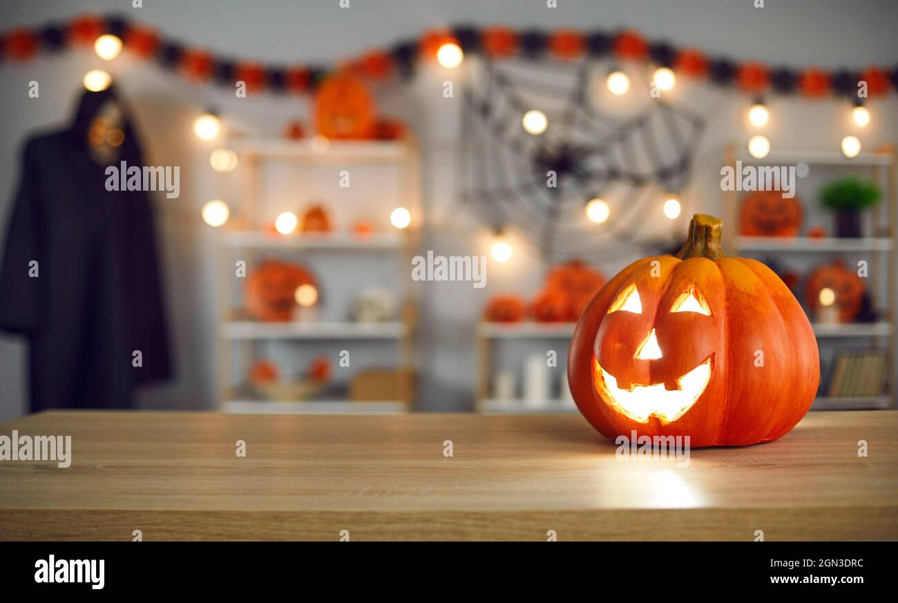 Ambiance festive Halloween avec une smiley Jack-O-lanterne sur la table dans la salle décorée Banque D'Images