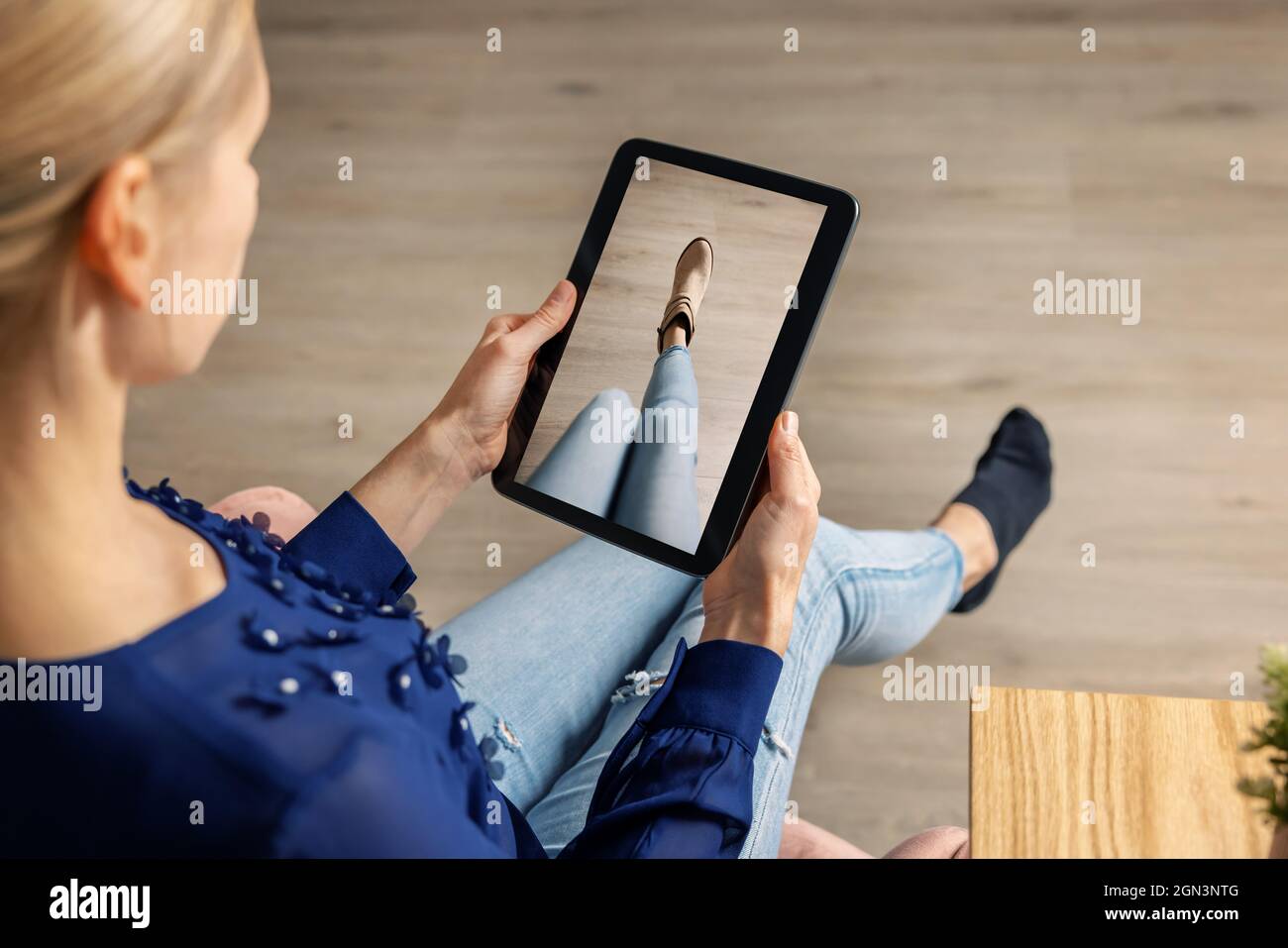 cabine d'essayage virtuelle - femme essayant des chaussures en ligne avec une tablette numérique Banque D'Images