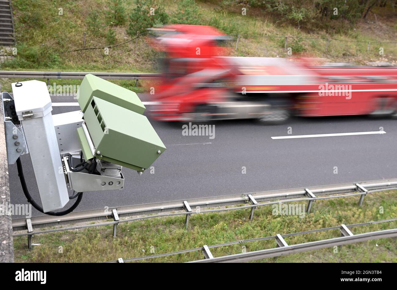 21 septembre 2021, Brandebourg, Wandlitz/OT Lanke: Un dispositif de reconnaissance de plaque d'immatriculation (KESY) est monté sous la main courante rouge d'un petit pont au-dessus de l'Autoroute A 10 près de la sortie Lanke. L'enregistrement automatique des plaques d'immatriculation, pratiqué depuis plusieurs années, est controversé, car des spectateurs ont été pris dans les manhunts. Avec la modification du Code de procédure pénale le 1er juillet de cette année, l'enregistrement de masse des plaques d'immatriculation n'est désormais autorisé que dans le cas d'une chasse à l'homme spécifique, mais n'est plus une surveillance permanente. Photo: Soeren Stache/dpa-Zent Banque D'Images